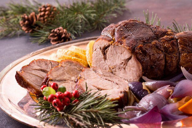 Hoher Winkel des Weihnachtssteaks auf Teller mit Tannenzapfen