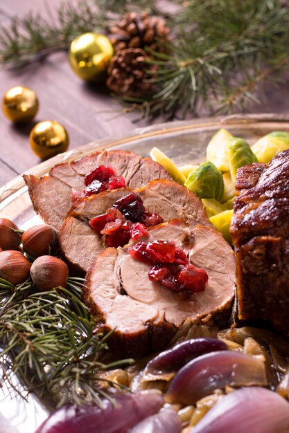 Hoher Winkel des Weihnachtssteaks auf Teller mit Tannenzapfendekor