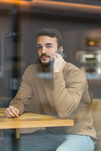 Kostenloses Foto hoher winkel junger geschäftsmann, der über telefon spricht