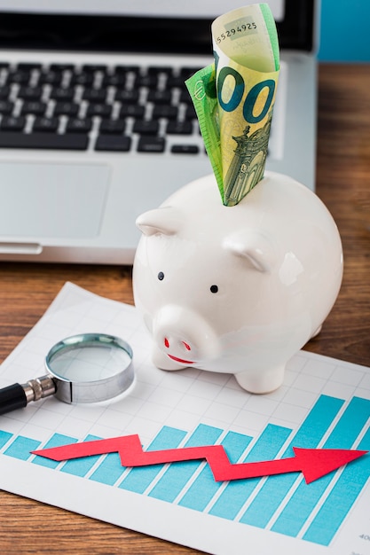 Kostenloses Foto hoher winkel von büroartikeln mit sparschwein und wachstumstabelle