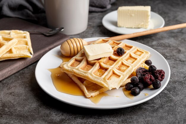 Hoher Winkel von Butter und Honig auf Waffeln