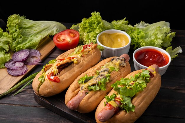 Hoher Winkel von drei Hot Dogs mit Salat und Sauce
