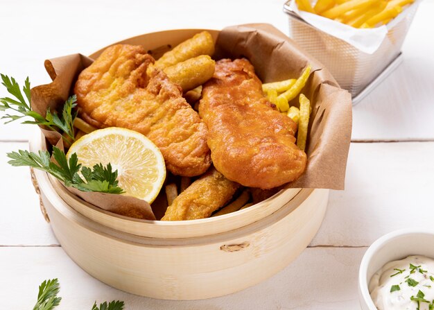 Hoher Winkel von Fish and Chips in Schüssel mit Zitrone