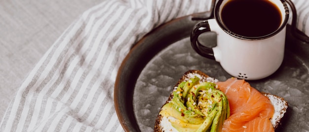 Hoher Winkel von Frühstücksbrötchen mit Lachs und Avocado mit Kopierraum