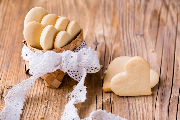 Hoher Winkel von herzförmigen Plätzchen im Korb mit Bogen