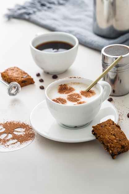 Hoher Winkel von Kaffeetassen mit Desserts und Teller