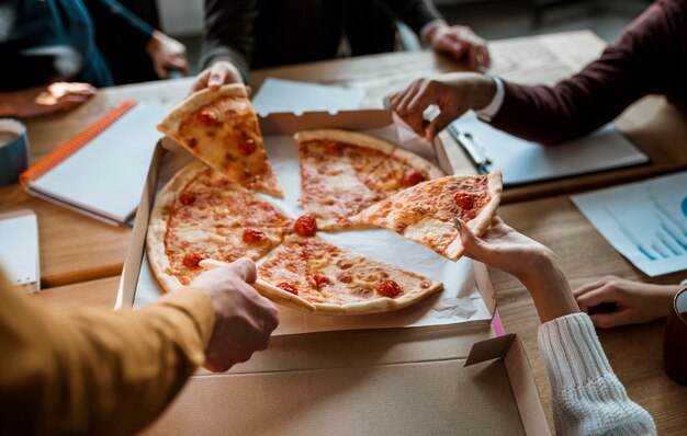 Hoher Winkel von Kollegen, die Pizza während einer Bürobesprechungspause haben