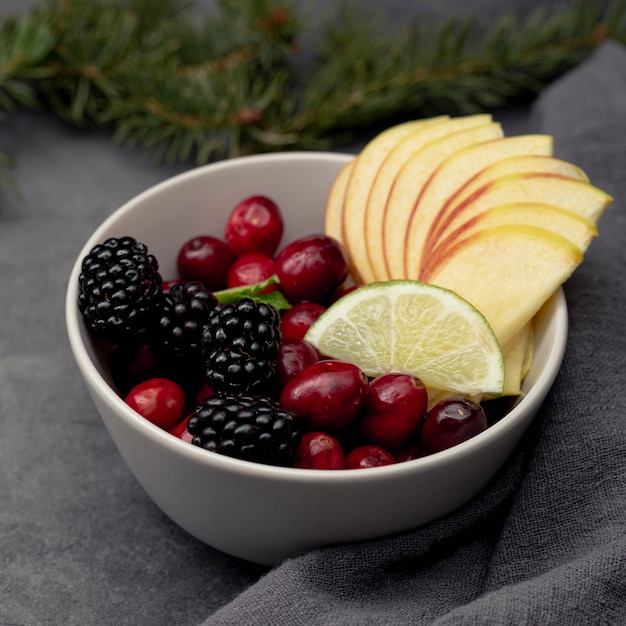 Hoher Winkel von Moosbeeren und von Apfelscheiben in der Schüssel