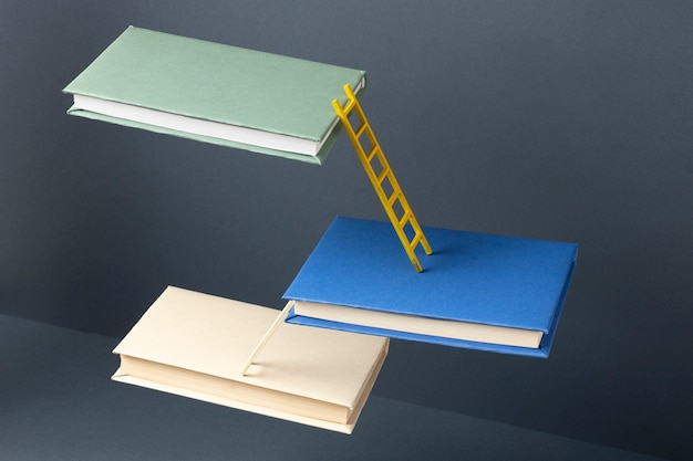 Hoher Winkel von schwebenden Büchern, die durch Leitern für den Bildungstag verbunden sind