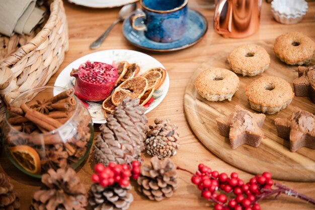 Hoher Winkel von Winterberry mit Tannenzapfen und Plätzchen