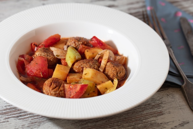 Kostenloses Foto hoher winkelschuss einer weißen schüssel fleisch- und gemüsesuppe auf einem holztisch