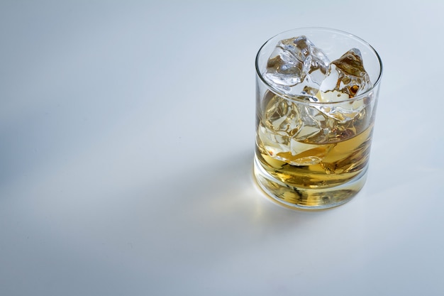 Hoher Winkelschuss eines Glases voll Eis und etwas Whisky lokalisiert auf einem weißen Hintergrund