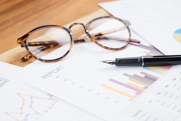 Holz Arbeitstisch Business Report analysieren Diagramm, Gläser, Stift.