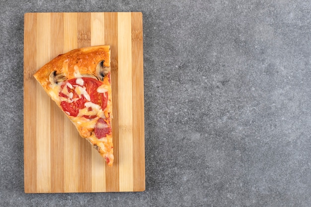 Holzbrett der leckeren hausgemachten Pizza auf Steintisch.