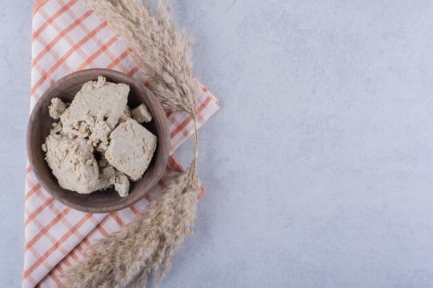 Holzschale mit leckerem Sonnenblumenhalva auf Stein.