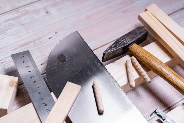 Holzstücke und Werkzeuge zum Bauen und Reparieren auf einem Holztisch