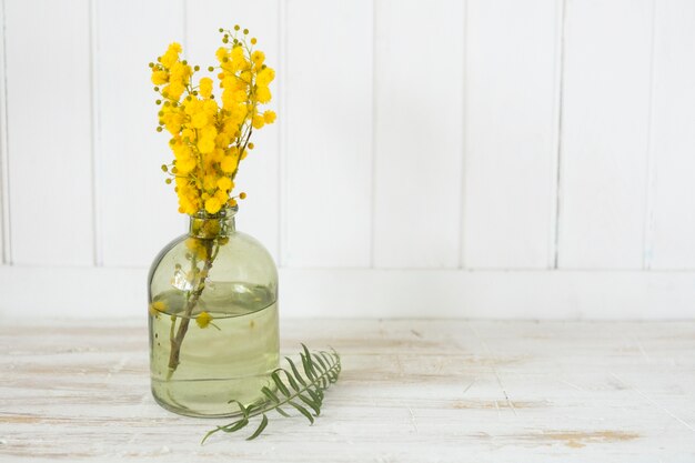 Holztisch mit dekorativen gelben Blüten