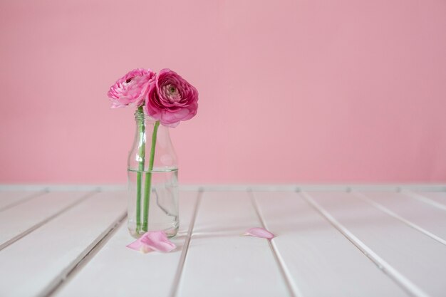 Holztisch mit niedlichen Blumen und Vase