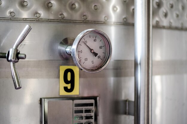 Holzweinfässer mit Thermometer in einem Weingut gelagert