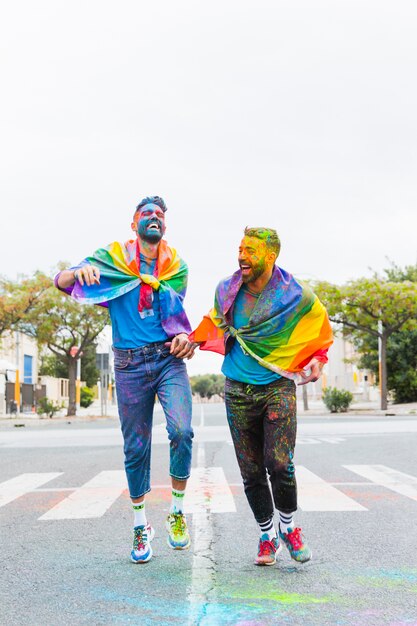 Homosexuelle Männer in mehrfarbigem Pulver, die Spaß auf der Straße haben