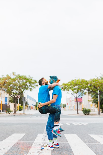 Kostenloses Foto homosexuelle paare, die auf holi-festival umarmen
