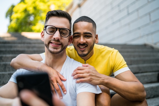 Homosexuelles Paar, das ein Selfie mit Handy nimmt.