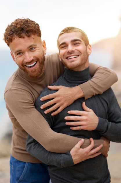 Kostenloses Foto homosexuelles paar, das liebevoll ist und zeit zusammen am strand verbringt