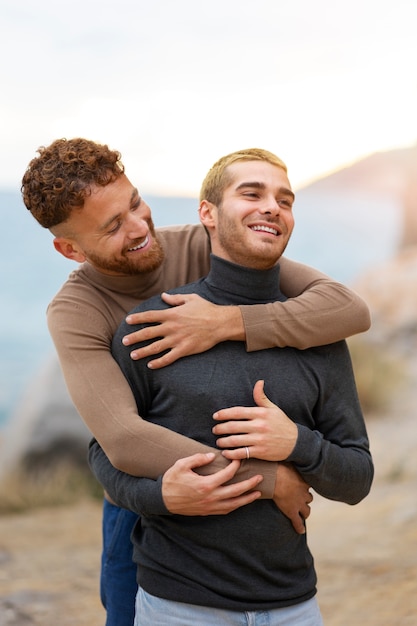 Kostenloses Foto homosexuelles paar, das liebevoll ist und zeit zusammen am strand verbringt