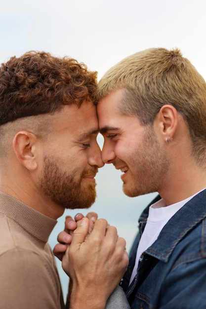 Kostenloses Foto homosexuelles paar, das liebevoll ist und zeit zusammen am strand verbringt