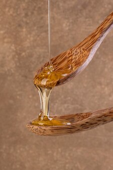 Honig tropft aus einem hölzernen honiglöffel Premium Fotos