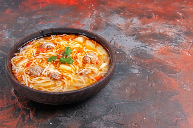 Horizontale Ansicht der köstlichen Nudelsuppe mit Hühnchen in einer braunen Schüssel auf dunklem Hintergrund