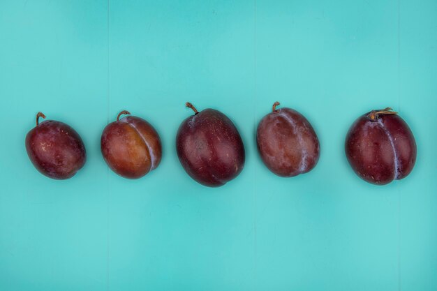 Kostenloses Foto horizontale ansicht von geschmackskönig pluots auf blauem hintergrund