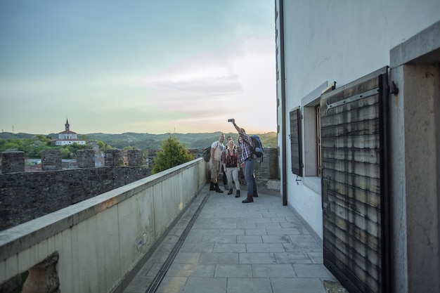 Horizontale Aufnahme einer Gruppe von Freunden, die Fotos machen und ihre Zeit auf dem Balkon genießen