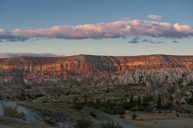 Horizontale Aufnahme einer Schlucht mit wenigen Pflanzen am Fuß und einigen Wolken am Himmel