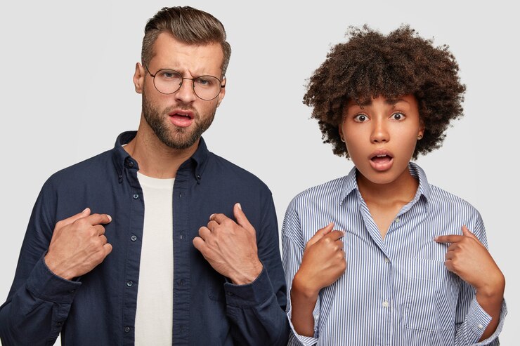 Kostenlose Foto horizontale aufnahme von empörten jungen frauen und männern verschiedener rassen, zeigen auf sich selbst
