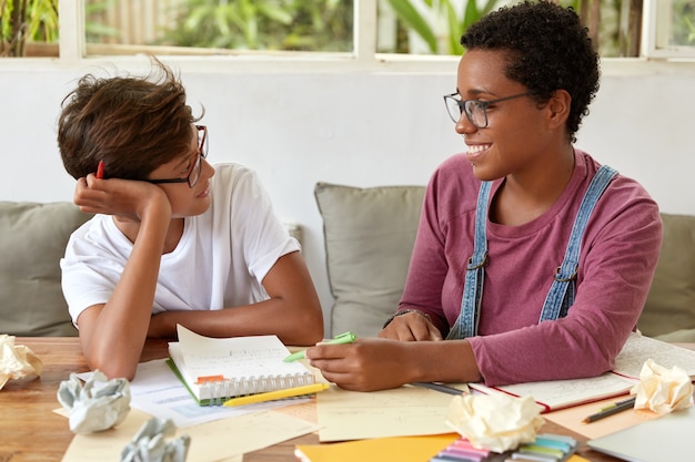 Horizontale Aufnahme von Frauen gemischter Rassen haben Konversation während des Lernprozesses