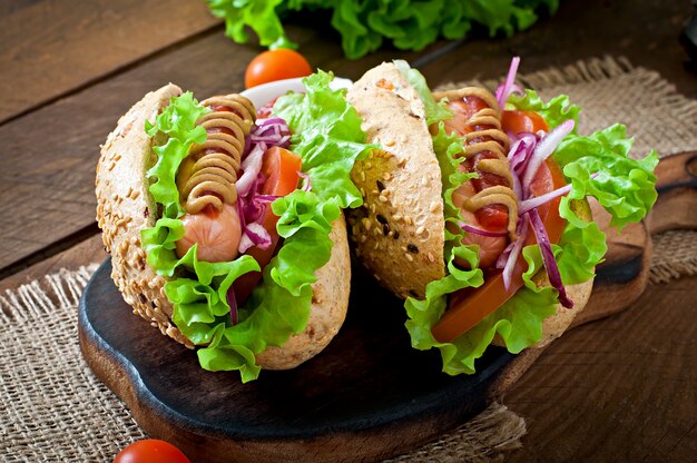 Hotdog mit Ketchup-Senf und Salat auf Holztisch.