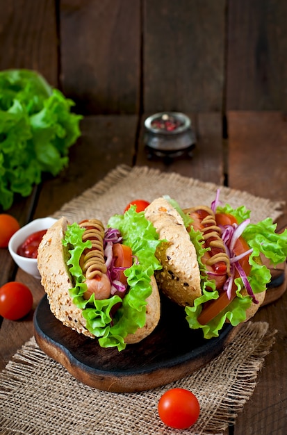 Hotdog mit Ketchup-Senf und Salat auf Holztisch.