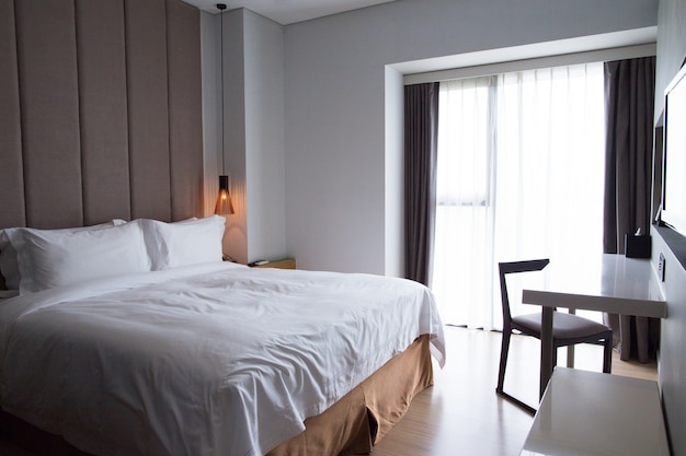 Hotelzimmer mit Doppelbett, Tisch und TV