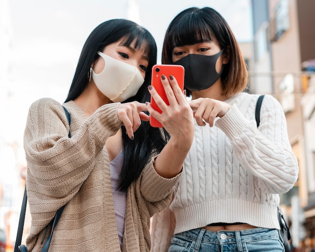 Hübsche asiatische Mädchen, die Gesichtsmasken tragen