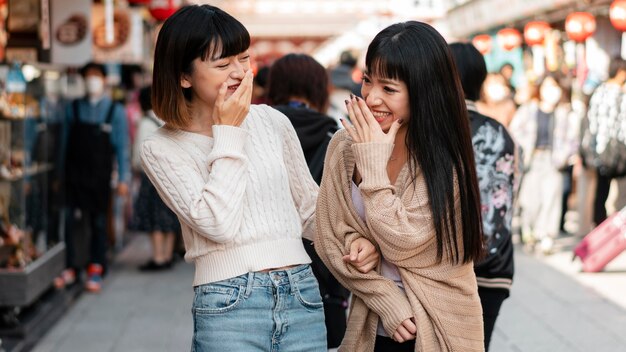 Hübsche asiatische Mädchen, die zusammen lachen