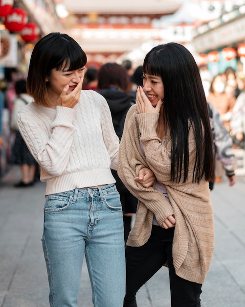 Hübsche asiatische Mädchen, die zusammen lachen