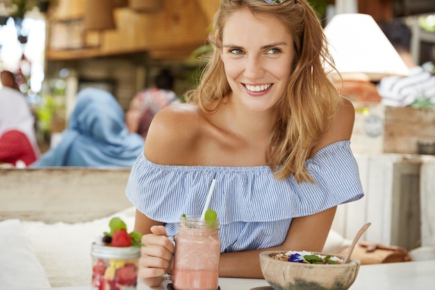 Kostenloses Foto hübsche blonde frau, die im café sitzt