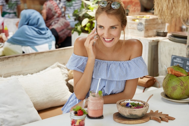 Kostenloses Foto hübsche blonde frau, die im café sitzt