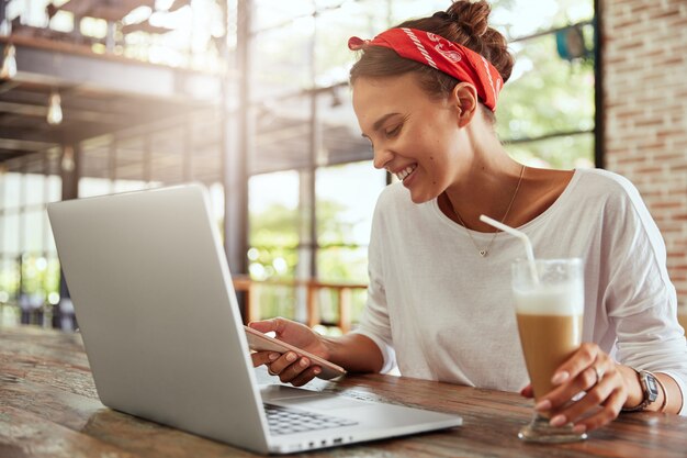 Hübsche blonde Frau, die im Café sitzt