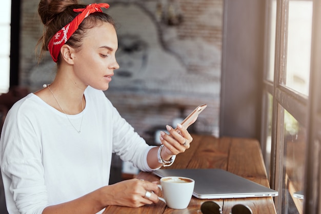 Hübsche blonde Frau, die im Café sitzt