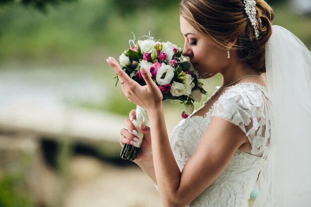 Hübsche Braut, die Blumen riecht