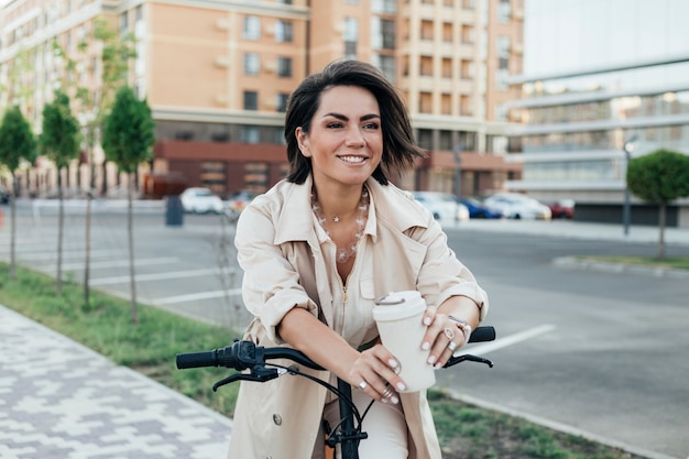 Kostenloses Foto hübsche erwachsene frau, die mit umweltfreundlichem fahrrad aufwirft