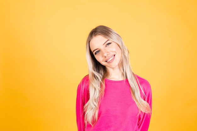 Hübsche europäische Frau in der rosa Bluse auf gelber Wand