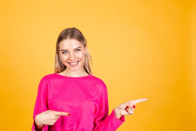 Hübsche europäische Frau in der rosa Bluse auf gelber Wand